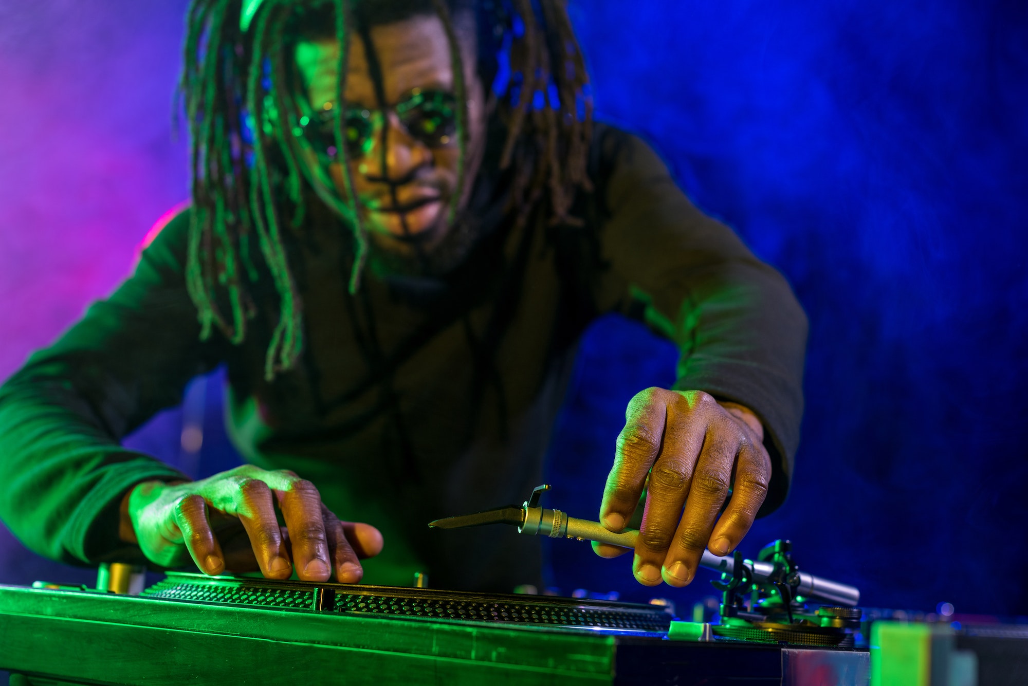 professional african american DJ with sound mixer in nightclub